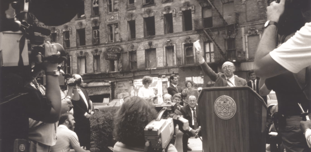 Jim Rouse standing at a podium speaking outside