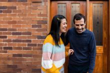 Couple in front of their wooden front door