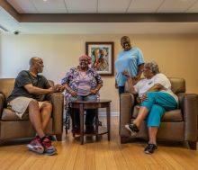 Four people sitting and standing together talking