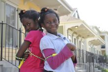 Two girls with jump rope standing in front of homes