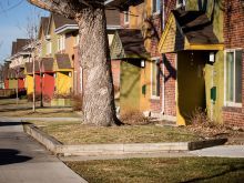 Streetview of apartments with yellow, green, and orange entrances