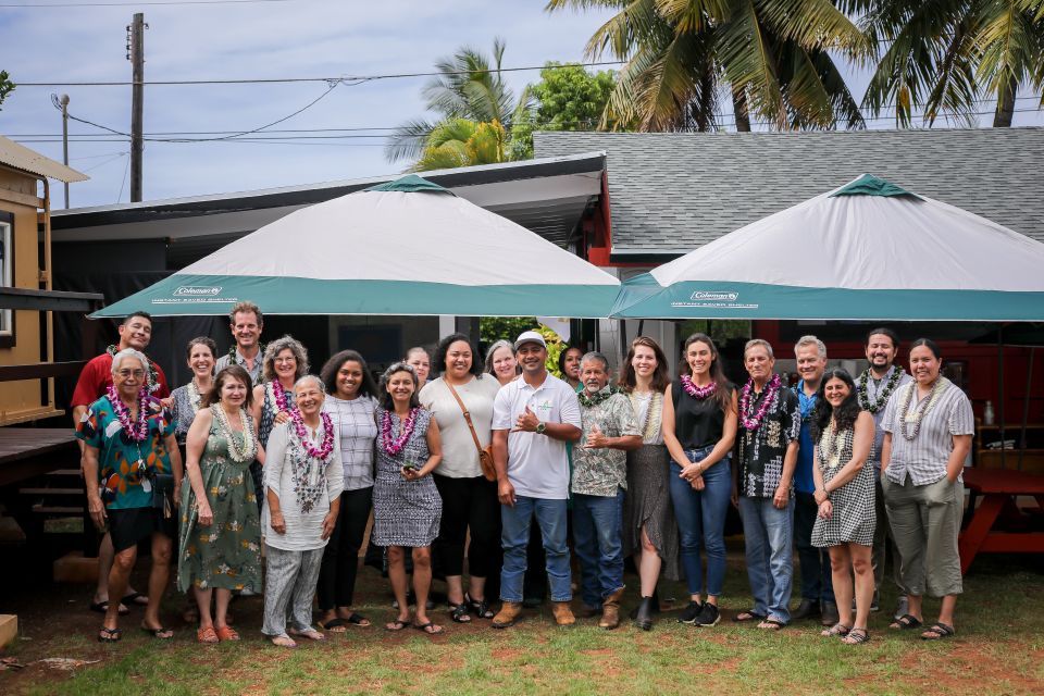 Enterprise, Homestead CDC, MASS Design, and community members gather for a photo by tents