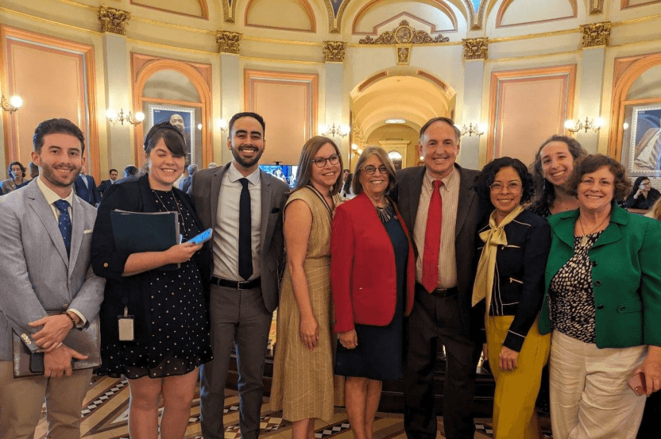 People in business attire standing on California Assembly floor