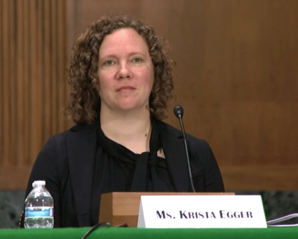 Woman seated at a table with a microphone