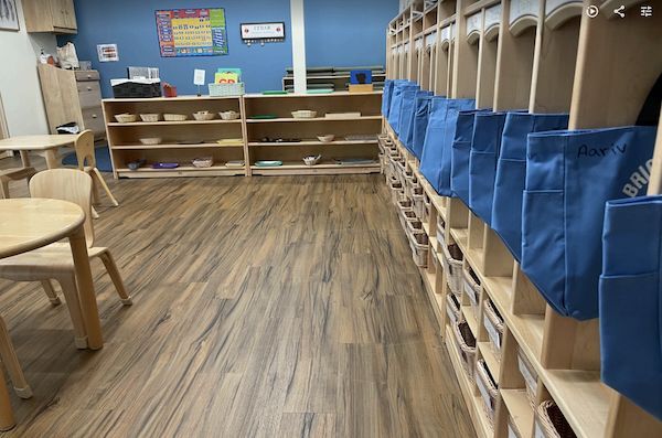 Blue bags hanging in open lockers in bright blue room