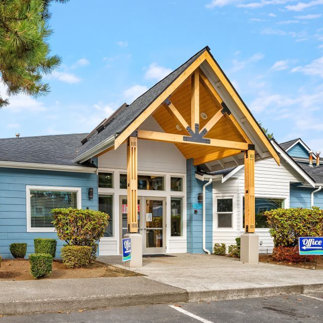 A blue, gray and wood clubhouse building for College Glen apartments