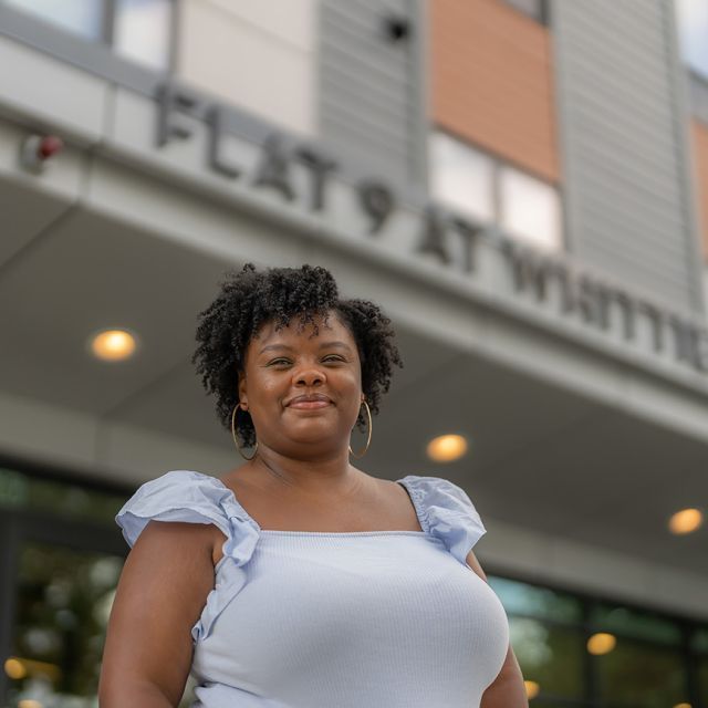 A woman standing outside in front of a building