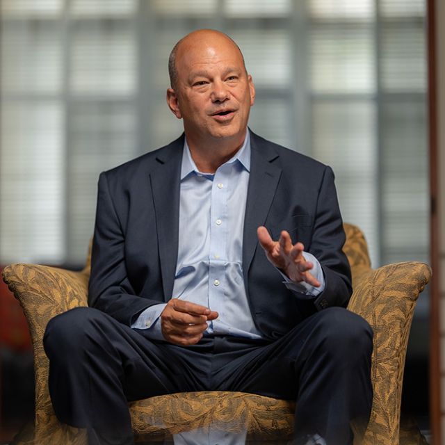 A man sitting in a chair answering questions